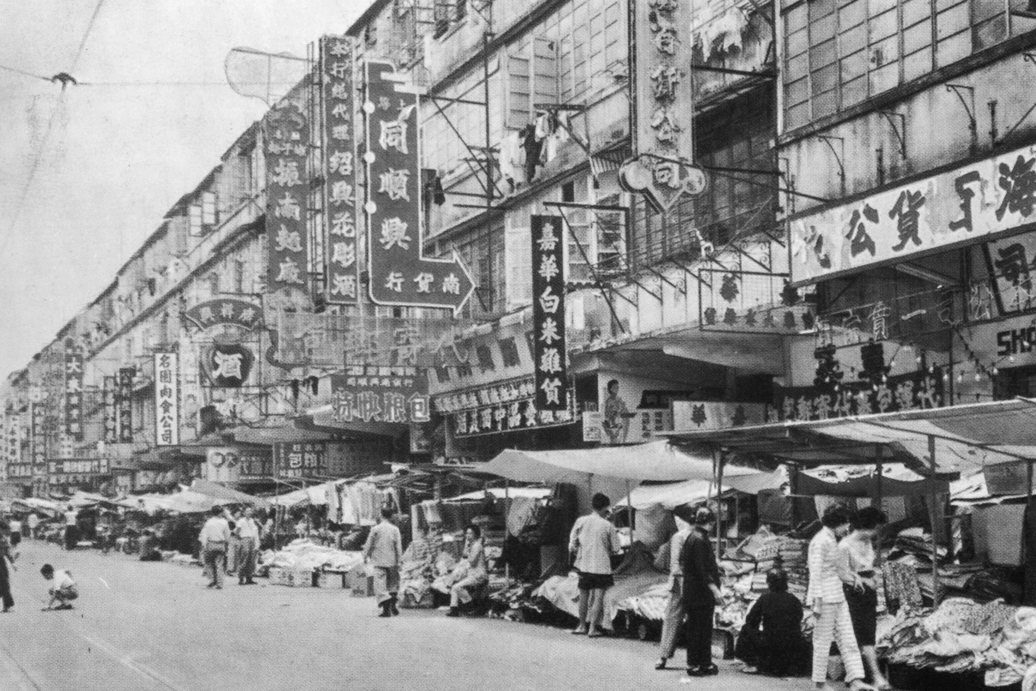 約1962年北角春秧街的店舖和小販攤檔，這一帶在日佔前後被稱為「四十間」。（圖片來源：鄭寶鴻提供）